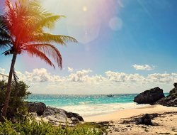 Cancun Beach Getty Sun shining down on a beach between cliffs in Cancun Mexico