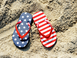 Memorial Day Travel Getty American flag sandals on a beach