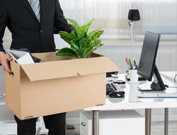 Fired executive man holding box of belongings leaving his office
