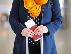 Passport Visa Immigration Immigrant Travel airport medical tourism (Getty/SbytovaMN) A woman holding a passport and plane ticket.