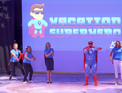 Vacation Superhero Dream Vacations General Manager of Network Engagement and Performance Drew Daly as the Vacation Superhero with members of the marketing team.
